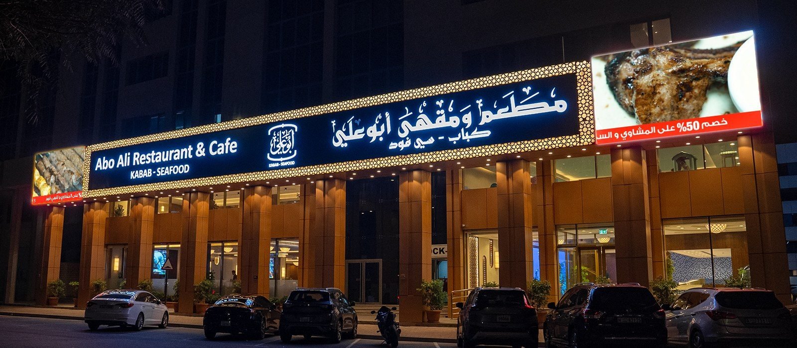 Illuminated storefront signboard in Dubai at night